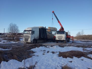 Разгружаем фуру с оцилиндрованным бревном.